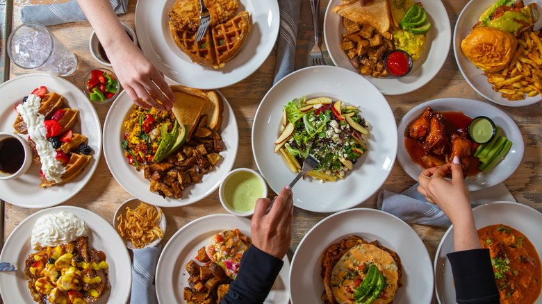 Sandwich, salad, toast, waffle, and other foods on restaurant table