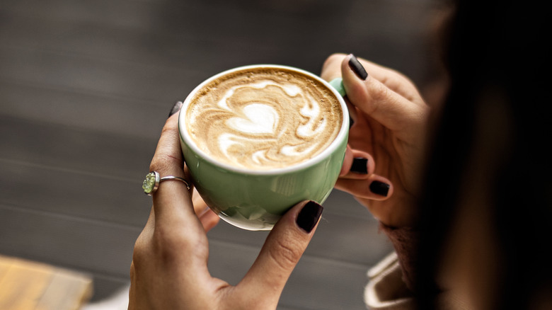 Person holding cup of coffee