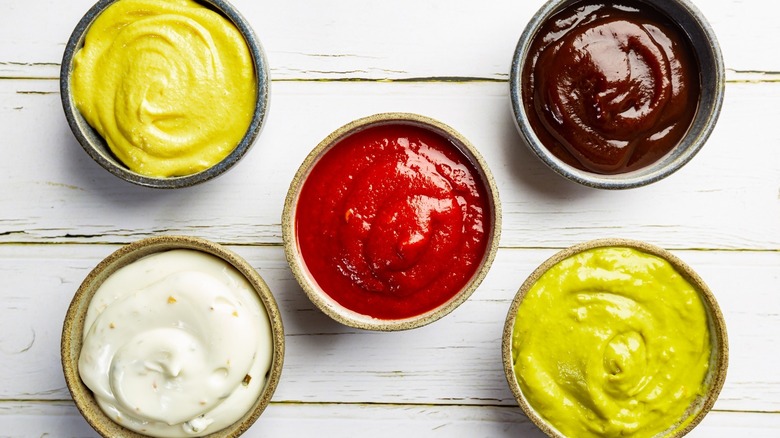 Small cups of ketchup, mustard, and other sauces. 