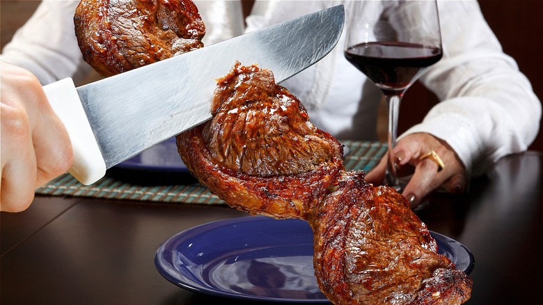 Waiter cutting Brazilian picanha steak