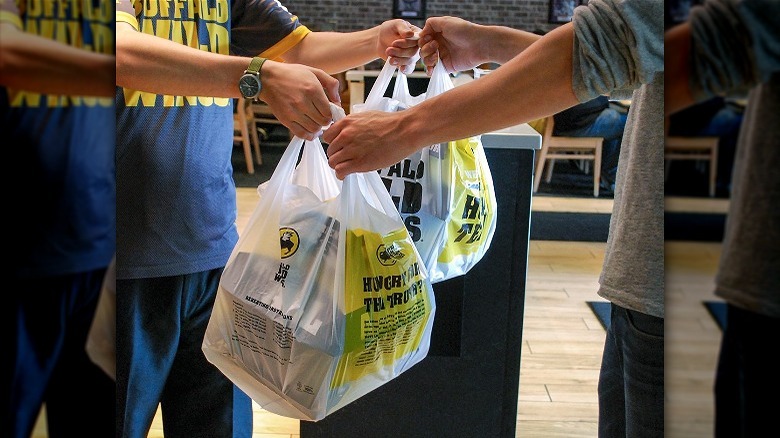 employee handing customer takeout bag