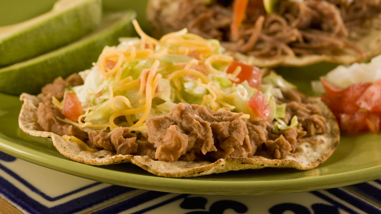 tostada with refried beans, cheese and vegetables