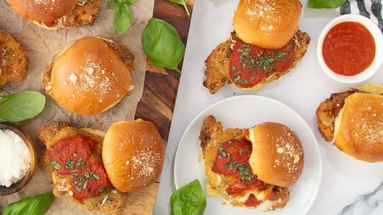 chicken Parmesan sliders on plates and serving boards
