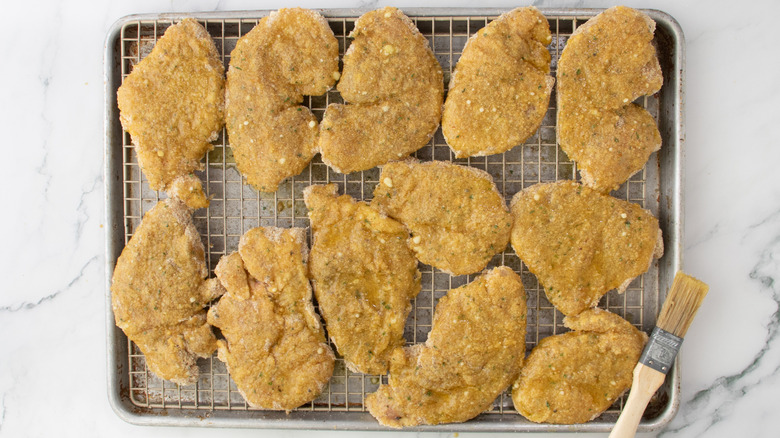cooked breaded chicken on a wire rack in a pan