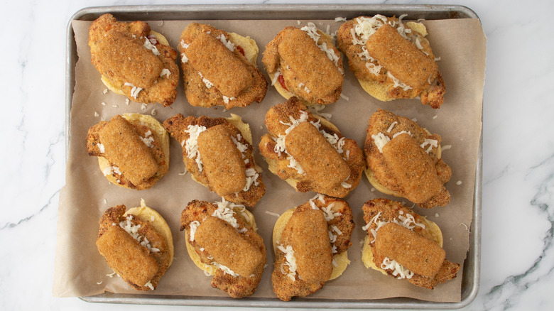 slider buns with chicken and mozzarella sticks in a pan