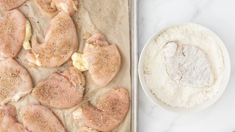 raw chicken in bowl of flour