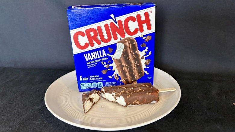 A Crunch ice cream bar and its box on a plate.