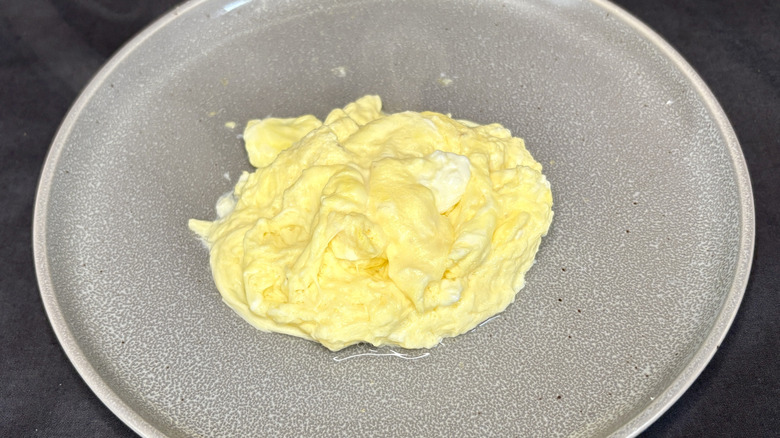 Boiled scrambled eggs on grey plate