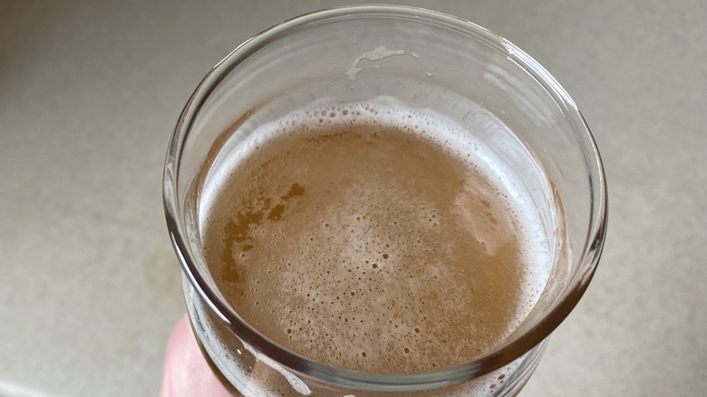 Hand holding glass of beer