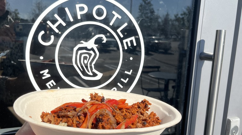 bowl of chorizo in front of Chipotle sign