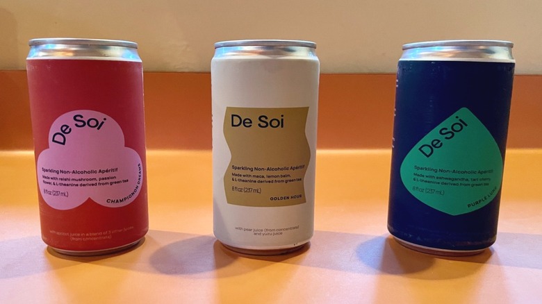 three cans of de soi on orange counter