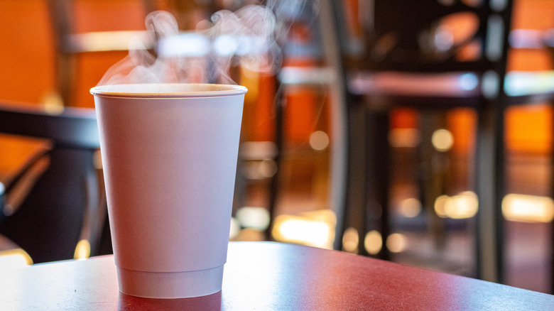 Cup of steaming coffee on restaurant table