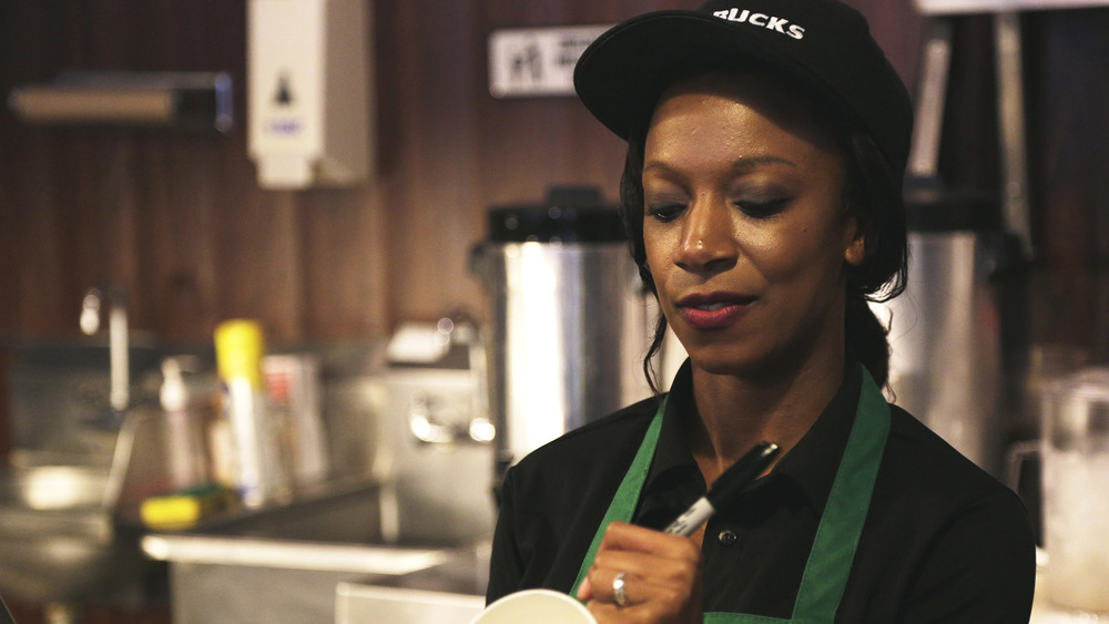 Starbucks worker writing on cup 