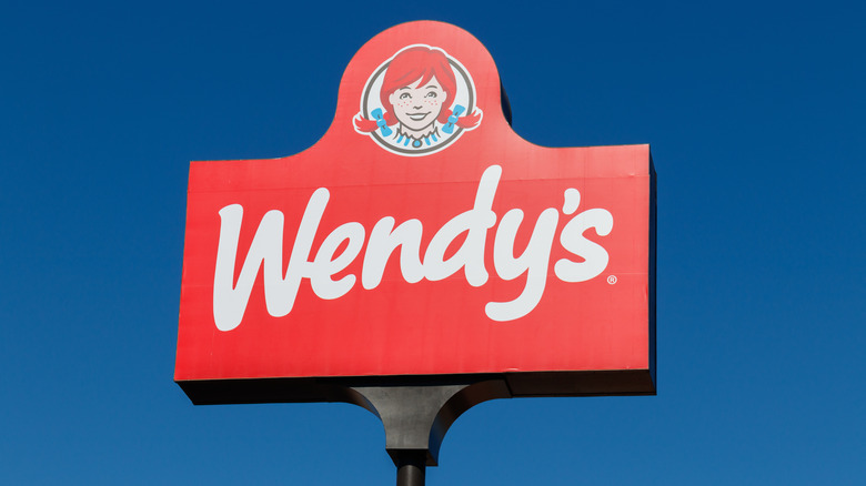 A Wendy's sign against a blue sky