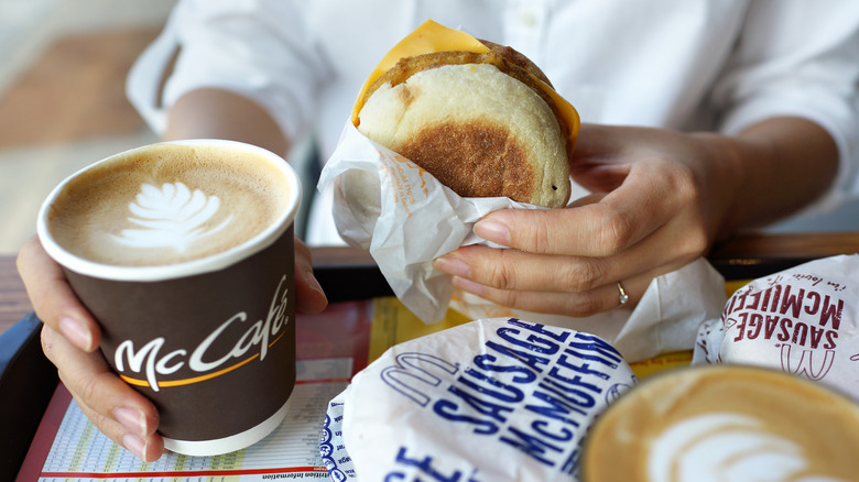 person holding Mcdonald's breakfast items