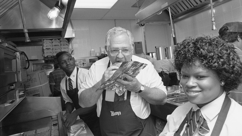 Dave Thomas eating a burger in a Wendy's kitchen