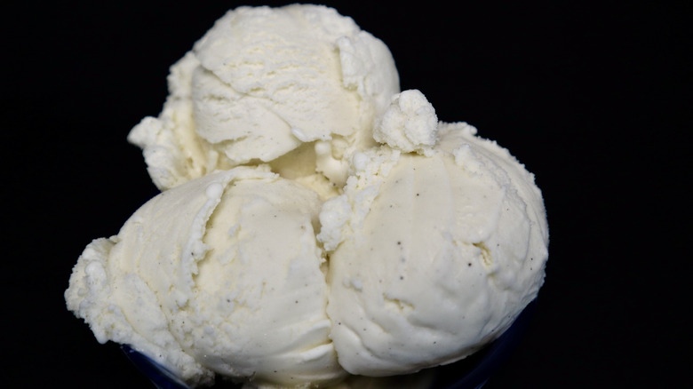 Three vanilla ice cream scoops against black background
