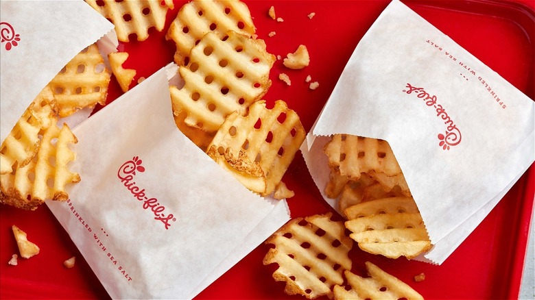 Bags of Chick-fil-A waffle fries on a red tray.
