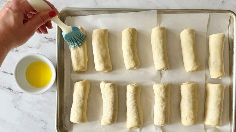 Brushing pepperoni rolls with melted butter
