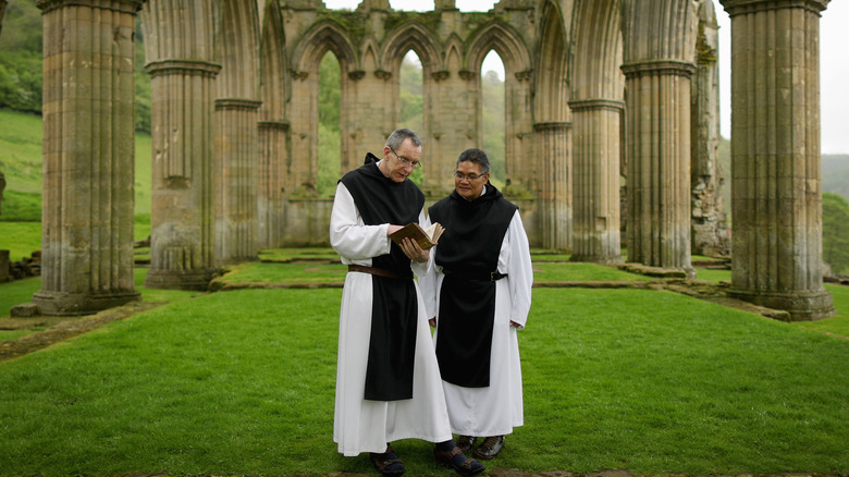 Two monks inside monastery ruins