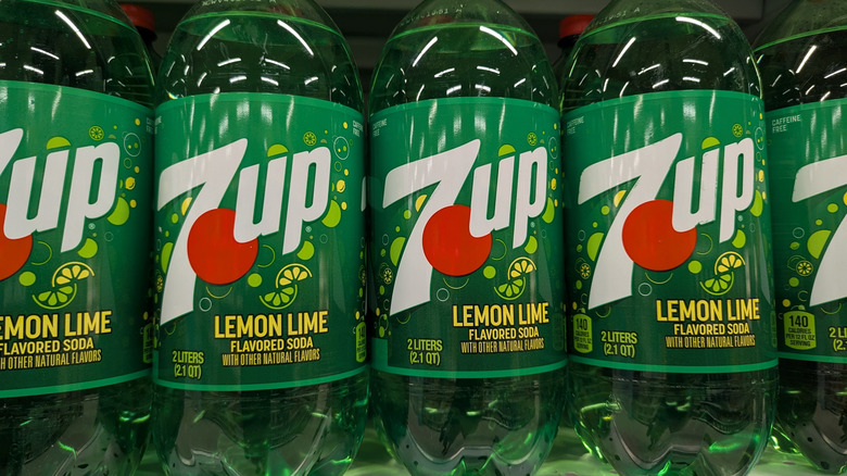 A row of 7UP 2-liter bottles on a store shelf.