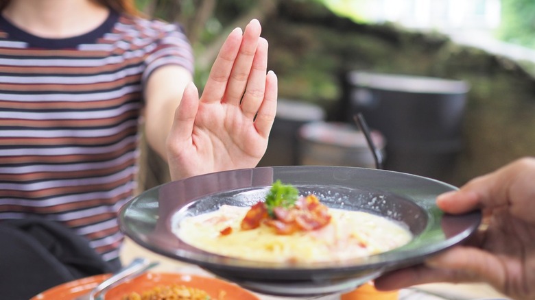 diner at a restaurant with outstretched hand