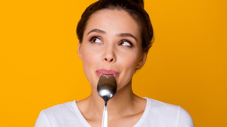 Person smiling with spoon in mouth
