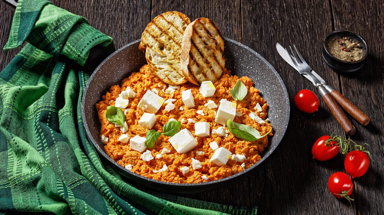 Strapatsada eggs with tomatoes in a bowl with grilled bread