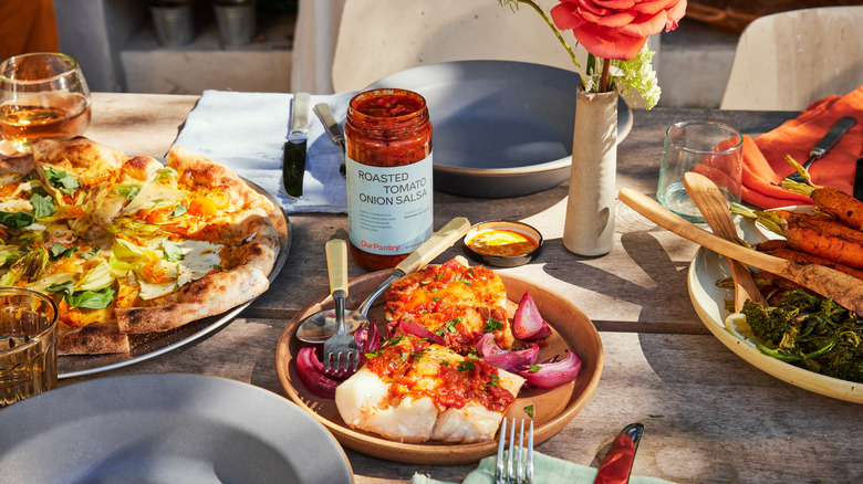 Plated fish with open jar of salsa