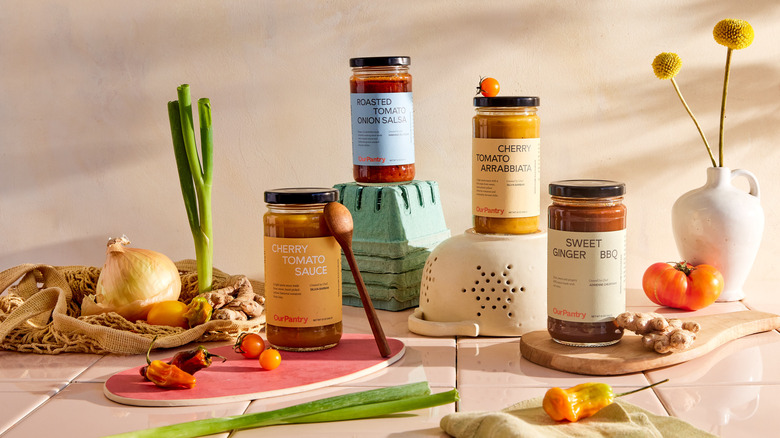 Four jars of sauces and ingredients on table
