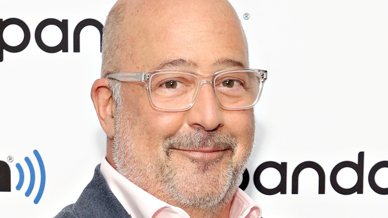 Andrew Zimmern smiling in glasses