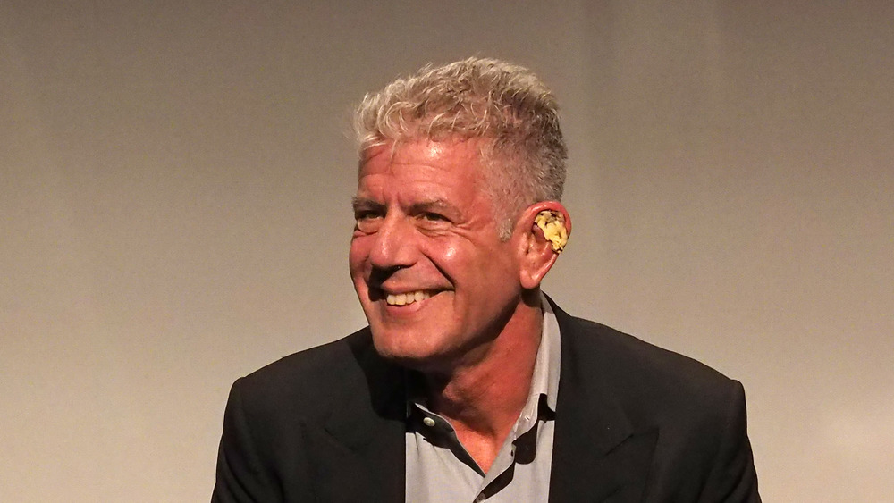 Anthony Bourdain with flower behind ear smiling