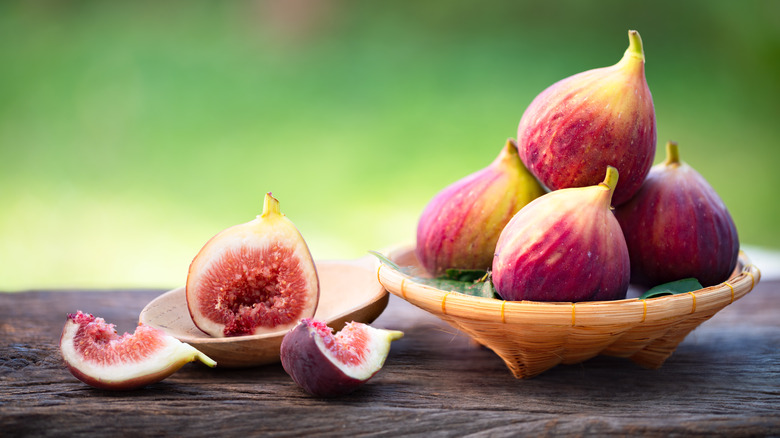 Ripe figs on wood table and in bowl