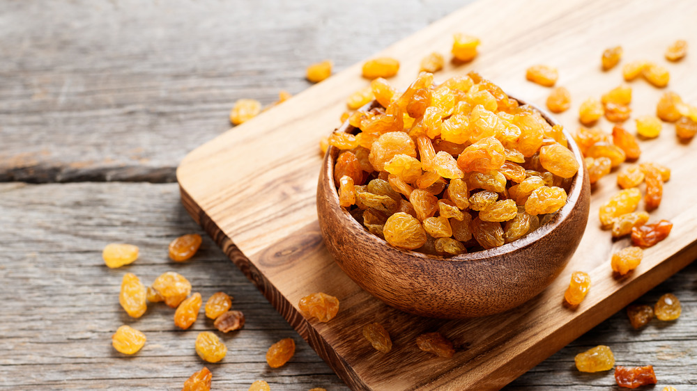 Golden raisins in a wooden bowl