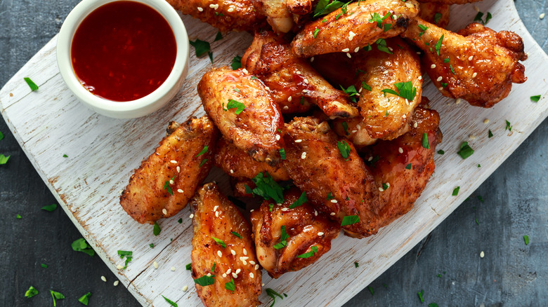 Sesame seeds on chicken wings next to sauce