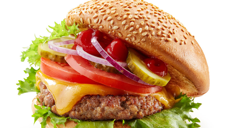 Burger with toppings inside sesame seed bun