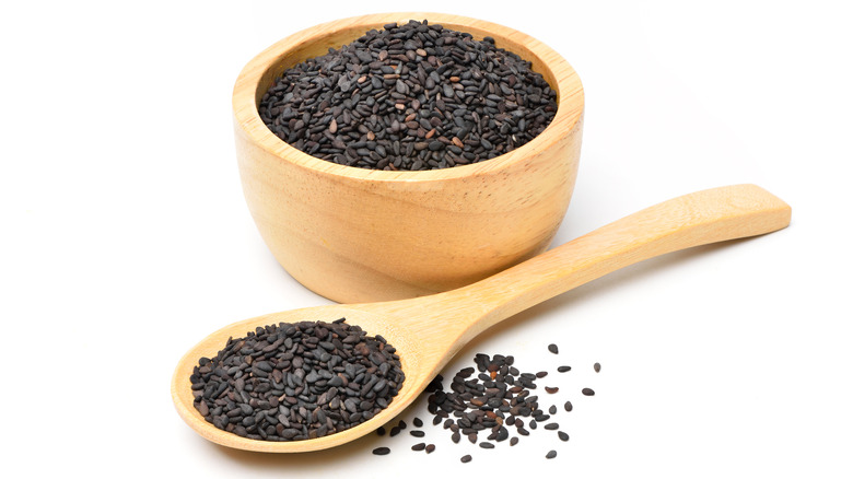 Black sesame seeds in a wooden bowl and spoon