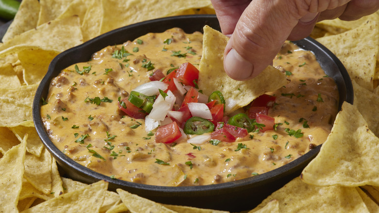 Dipping chip in nacho cheese