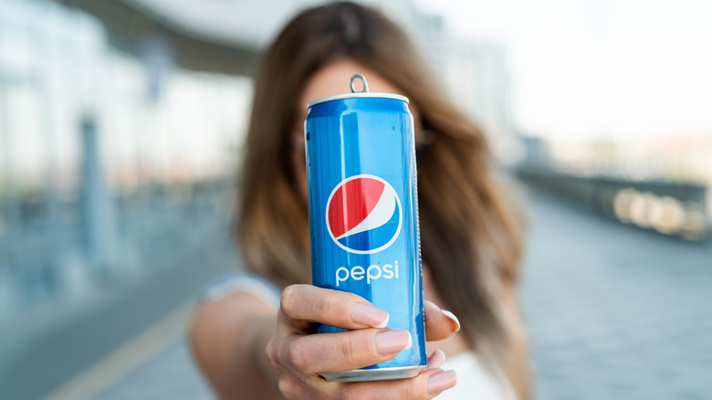 Woman holding a Pepsi can
