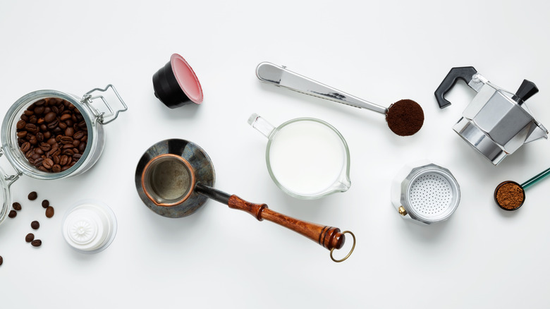 Tools for making coffee spread out on white surface.