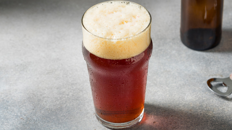 Amber-colored beer in a pint glass with bottle opener