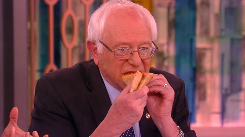 Bernie Sanders biting into folded slice