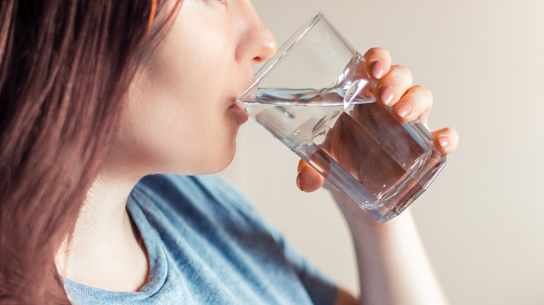 Person drinking water from glass
