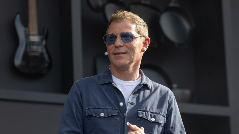 Bobby Flay wears a mic at a speaking event