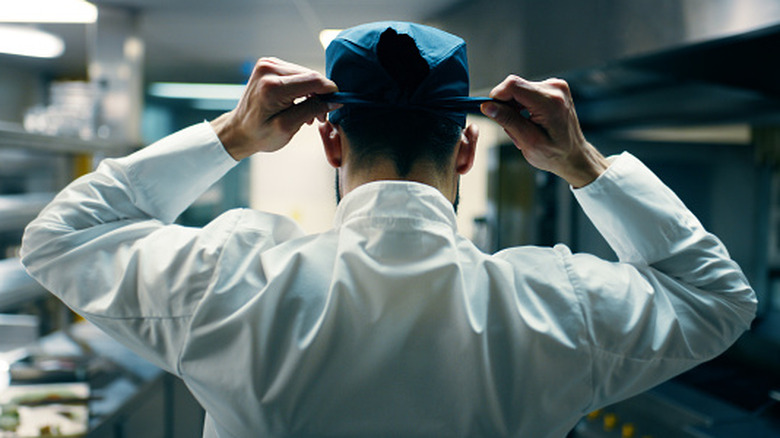 chef in kitchen preparing head cover
