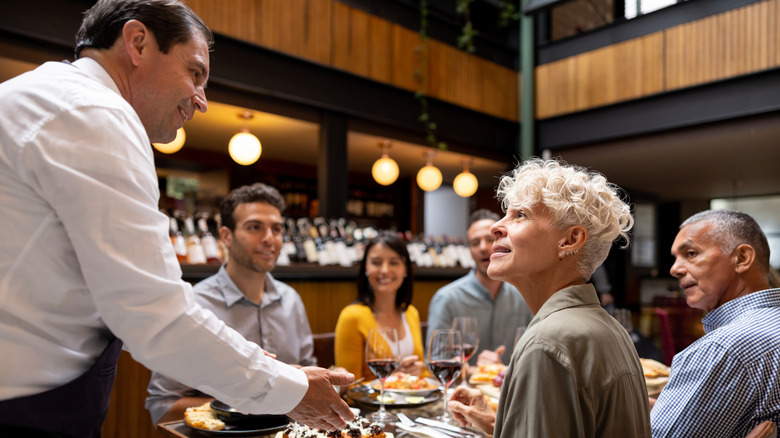 chef talking to customers at table