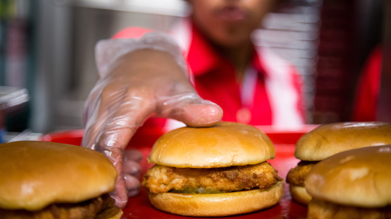 hand reaching for chicken burger