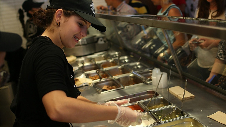 Chipotle employee making meal