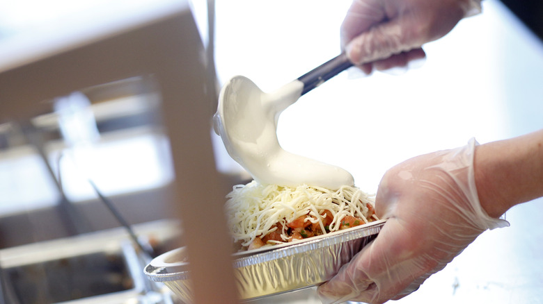 Chipotle employee making burrito bowl 