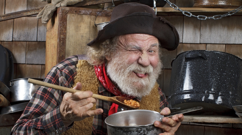 cowboy eating beans from a pot